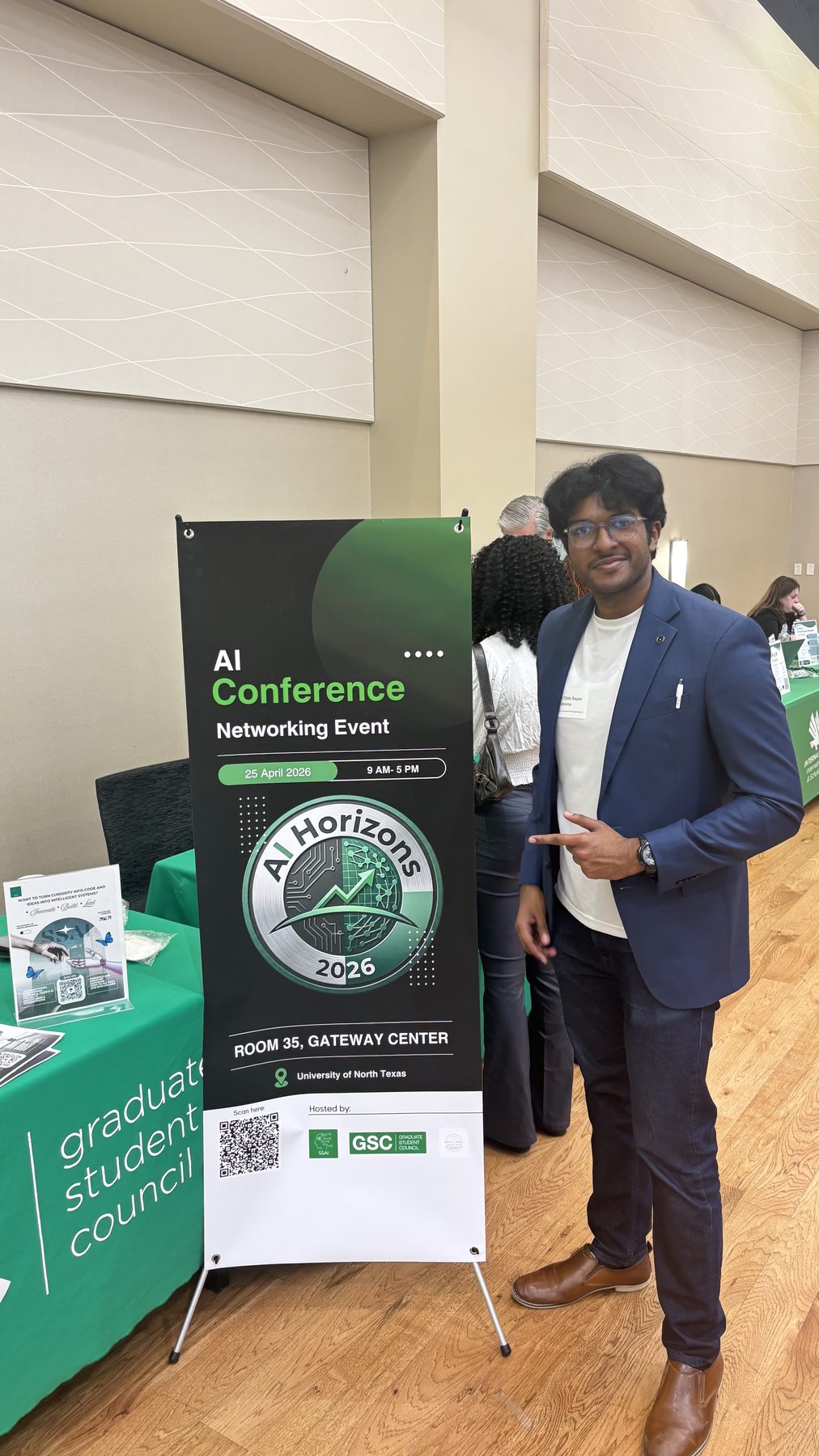 Samuel beside the AI Horizons 2026 conference banner at the Gateway Center
