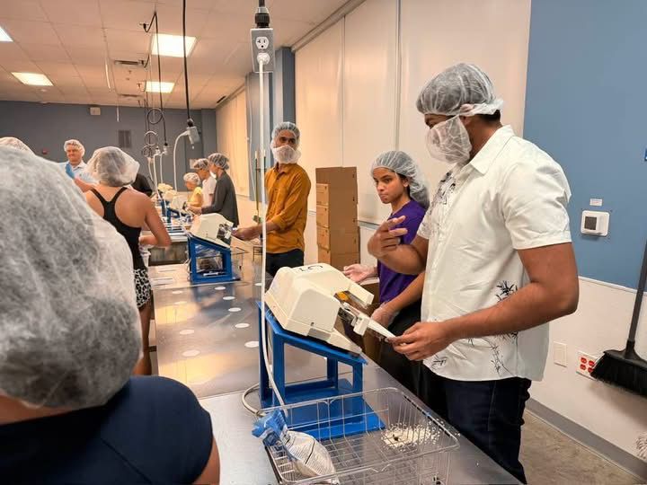 Samuel in a hairnet working the packing line at Feed My Starving Children
